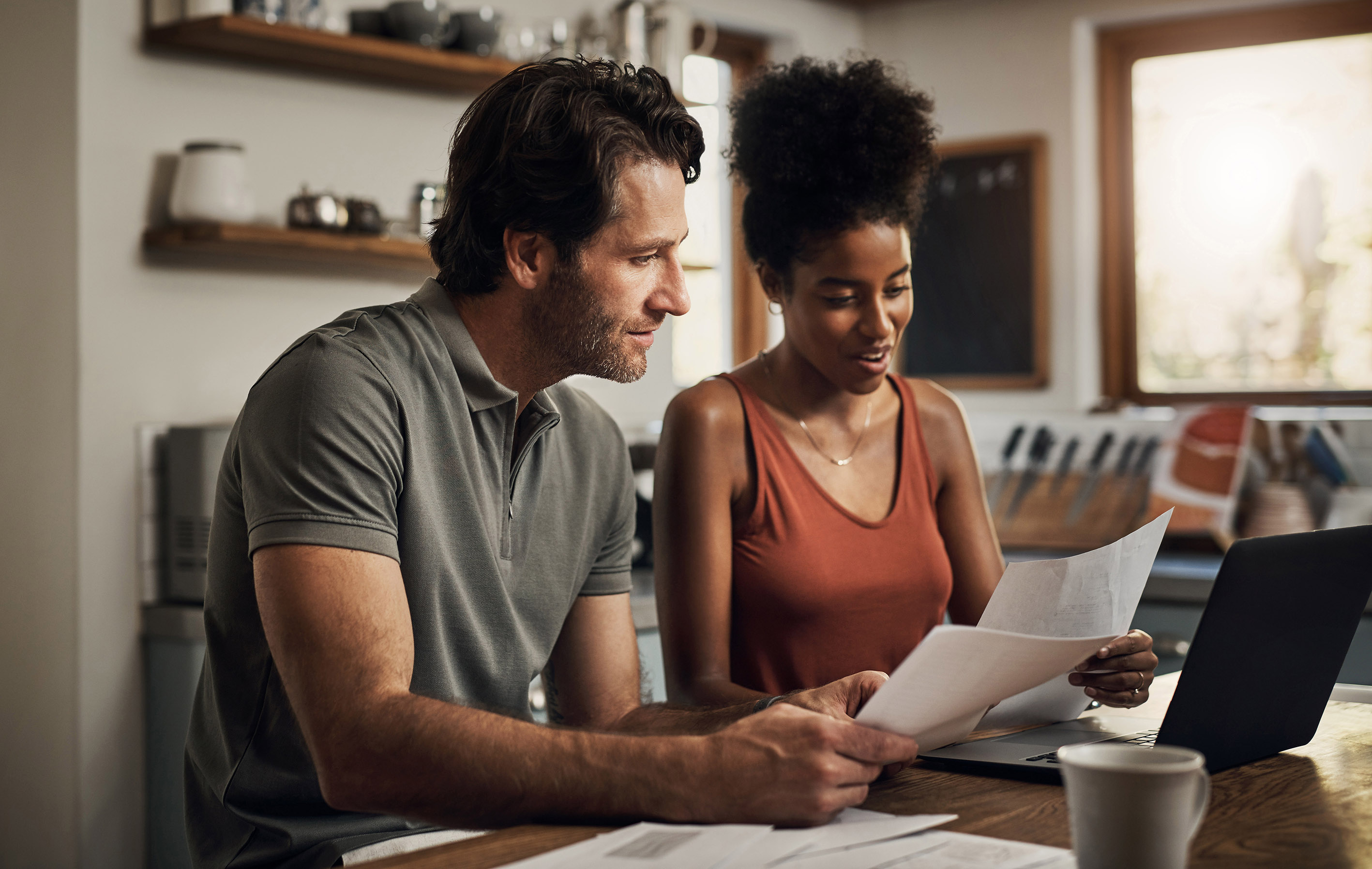 Couple sat at a desk looking over paperwork 