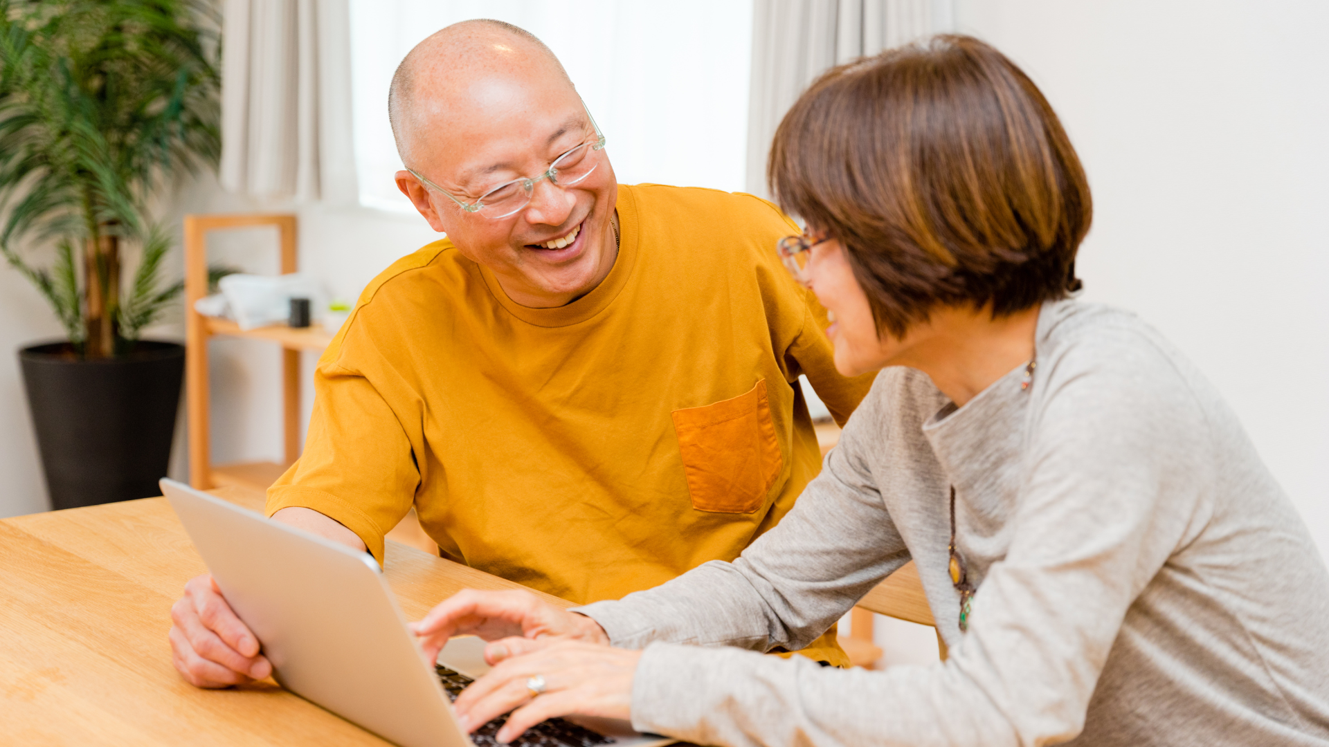 Man and woman sat at a table with a laptop
