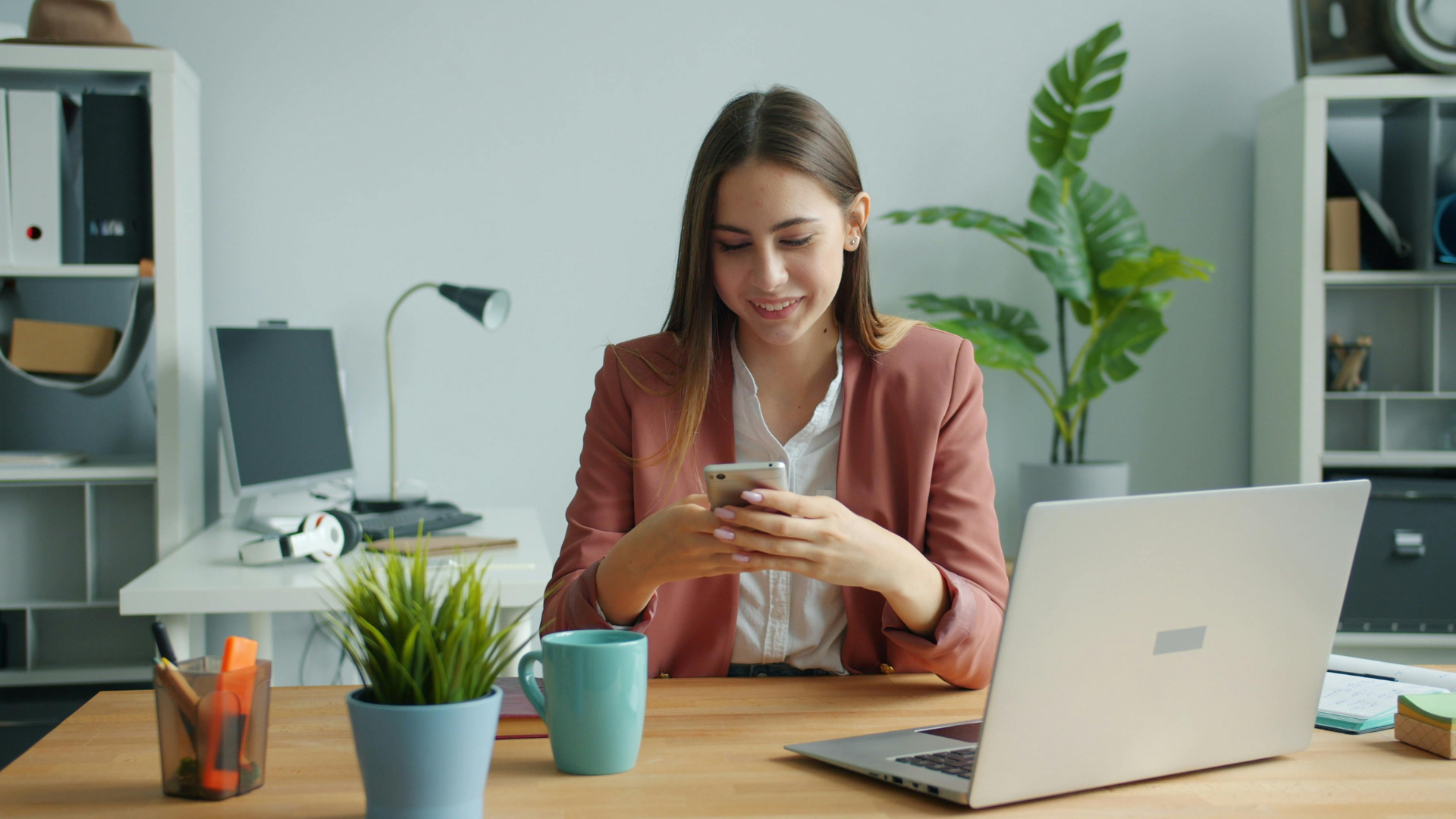 Young professional using her phone in the office.
