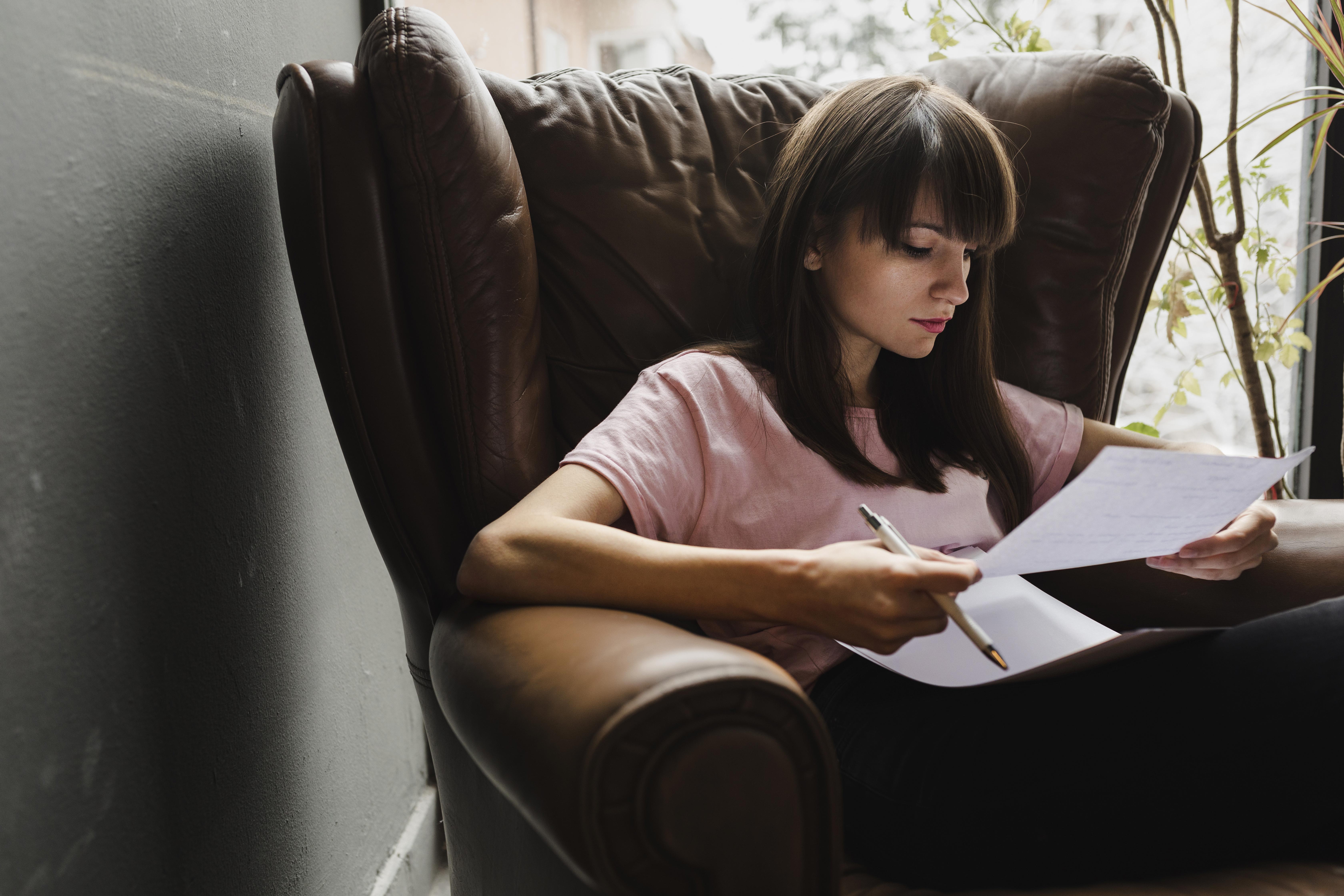 Woman sat in a chair filling out ISA forms.