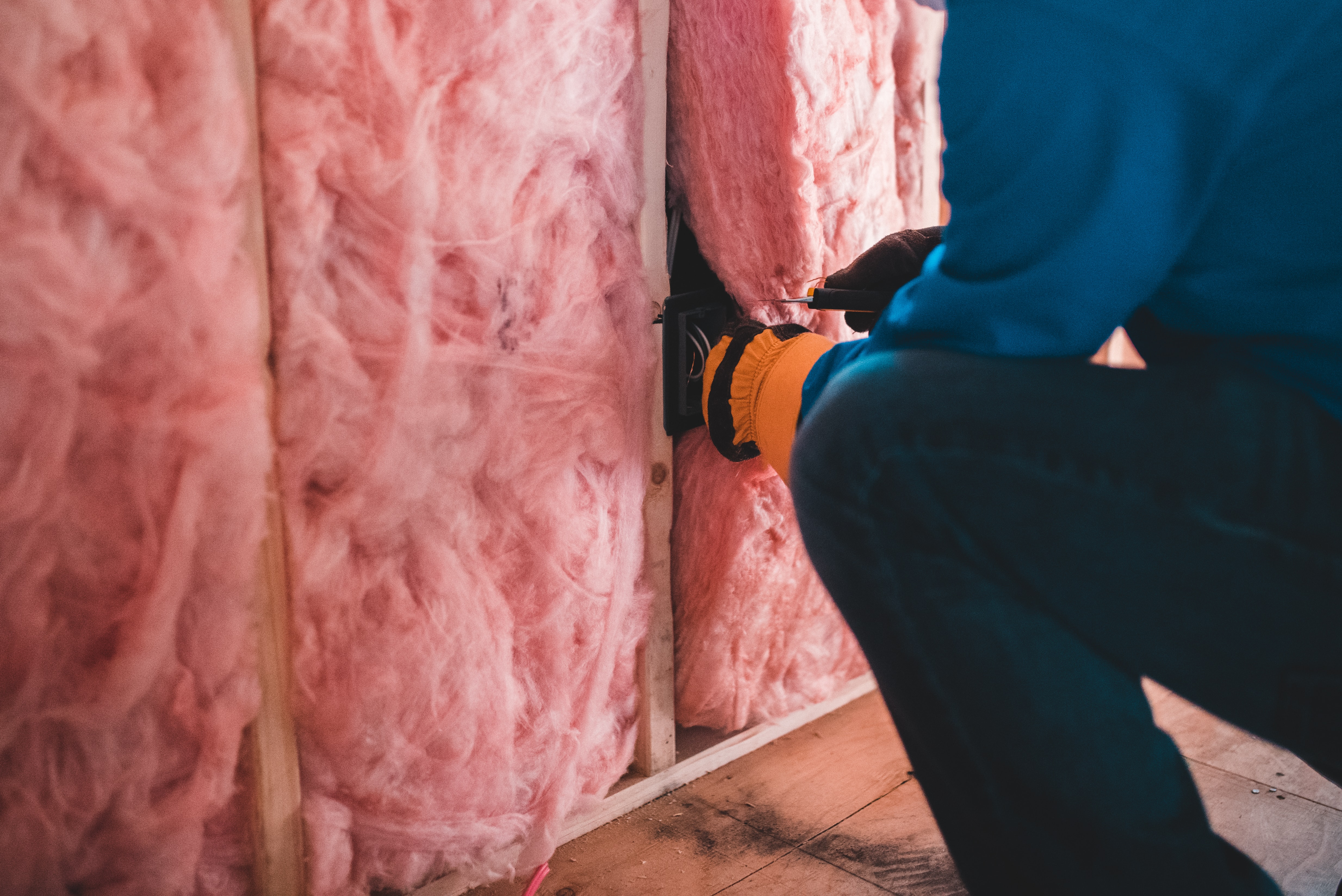 Man installing new wall insulation to represent EPC rating requirements