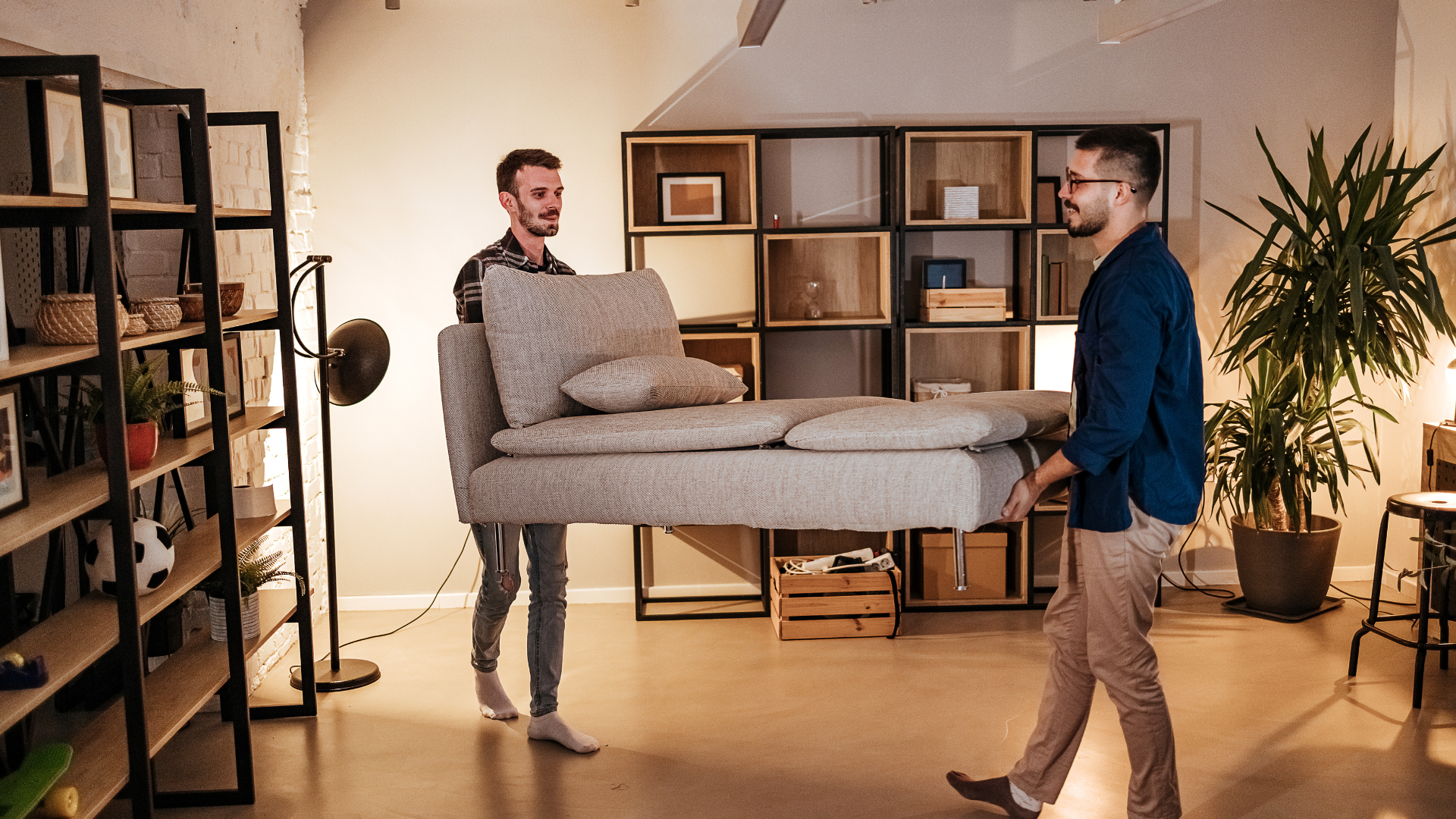 Two men carrying furniture into their new home