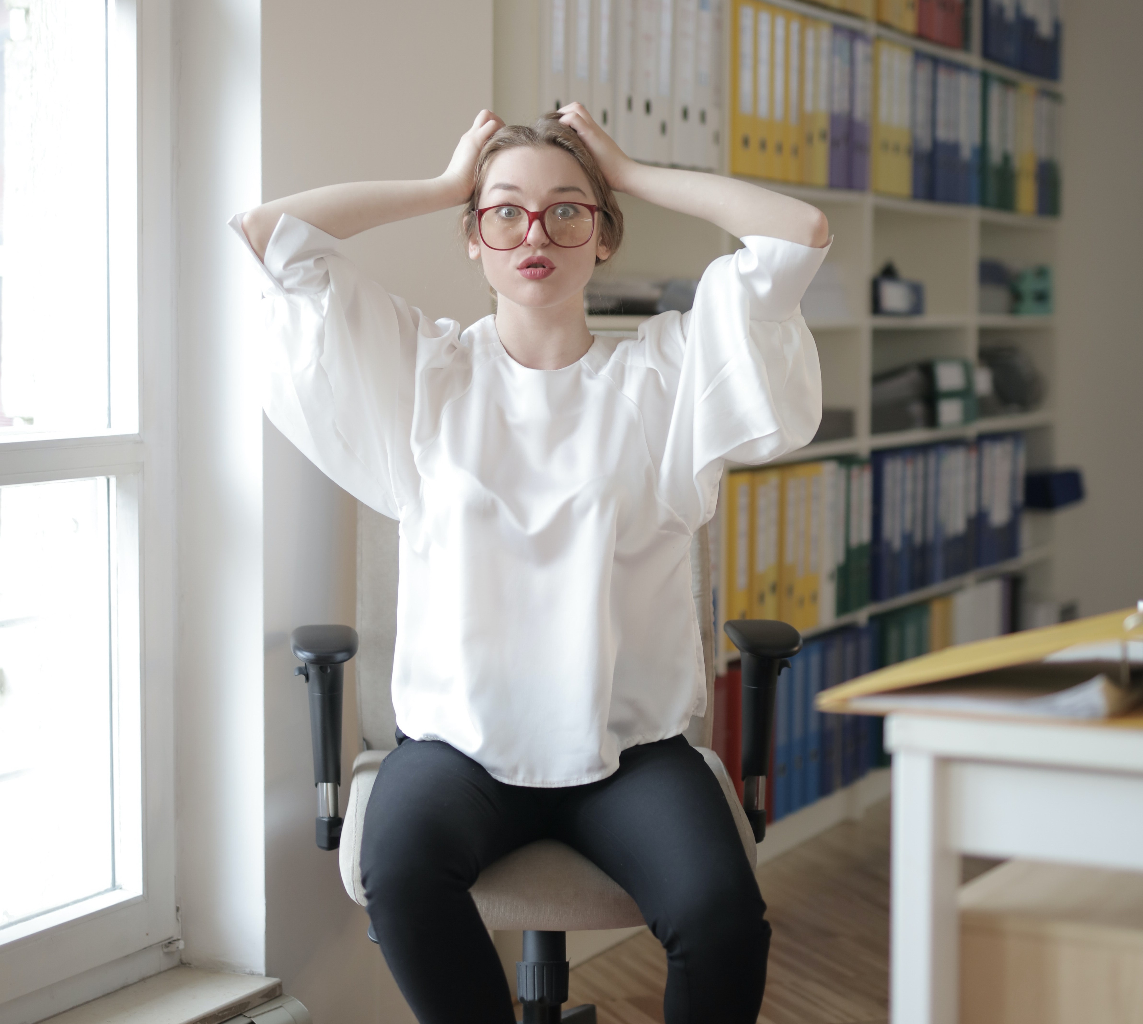 Woman with hands on her head and a worried expression.