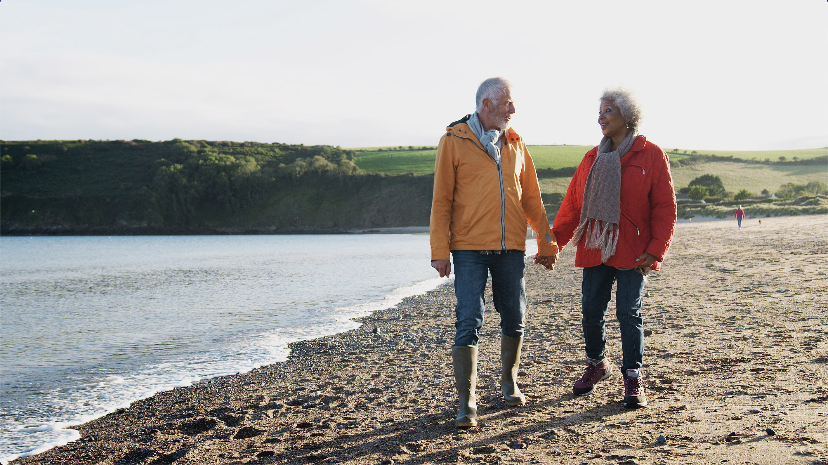 A man and woman holding hands on a beach