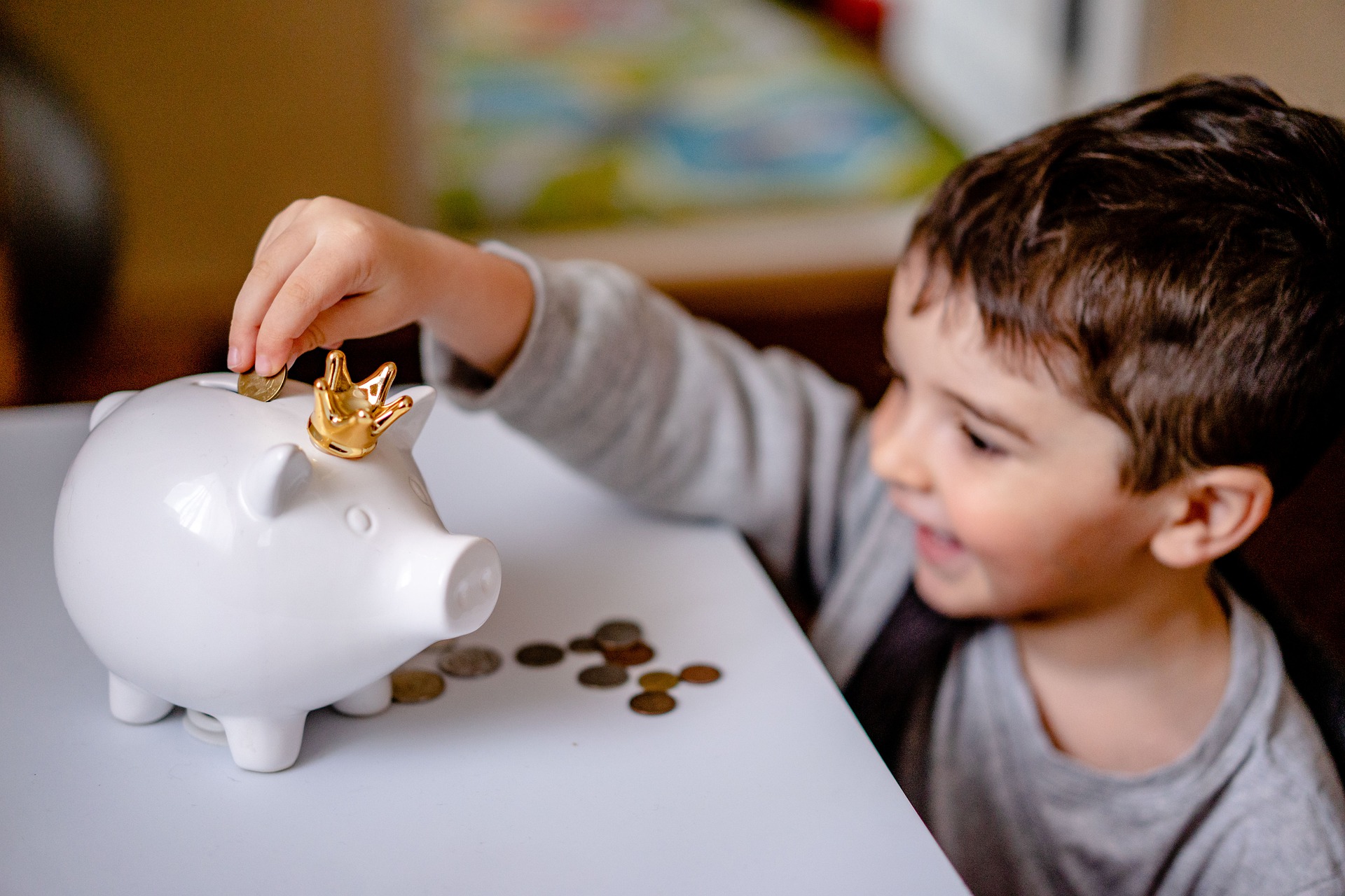 Child putting coins in a piggy bank